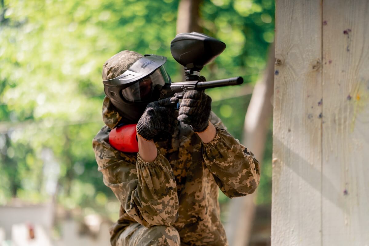 Osoba w stroju ochronnym gra w paintball na firmowe eventy Białystok.